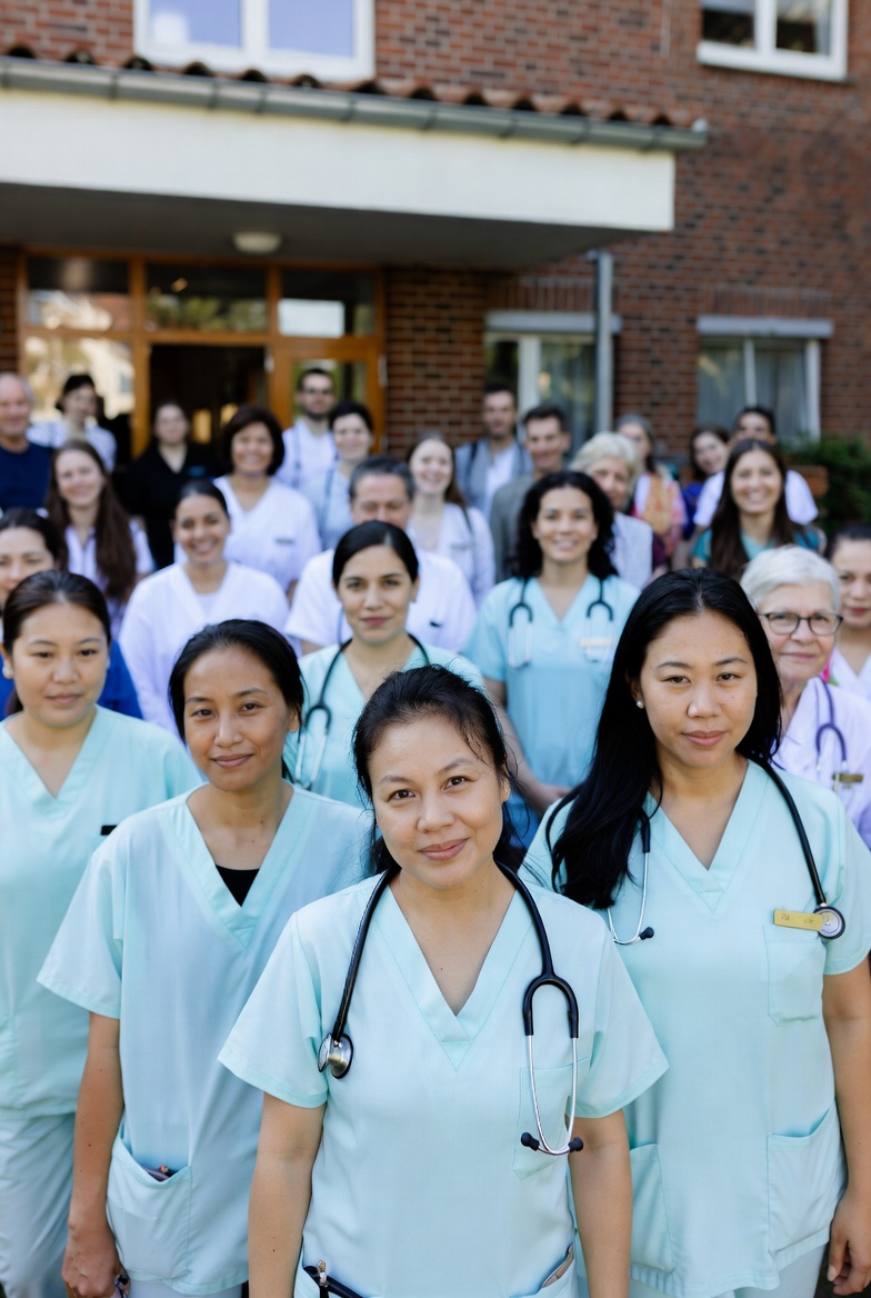 Internationales Pflegeteam vor einer Pflegeeinrichtung